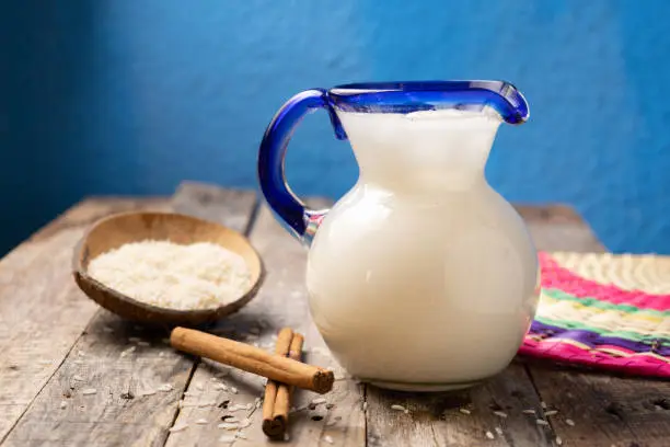 Traditional mexican rice horchata with cinnamon on wooden background