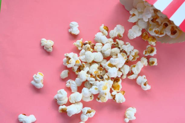 istock top view of popcorn spilling on pink background 1217714193