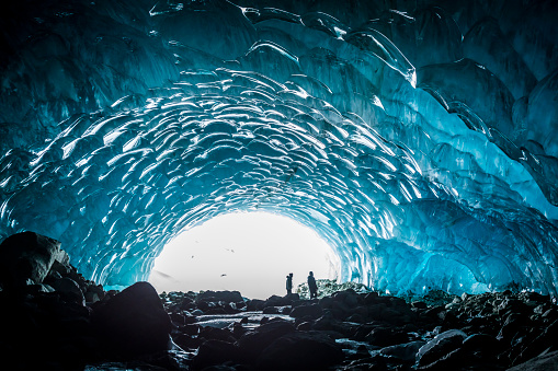 Tourists exploring glacial ice cave near Whistler, Canada.
