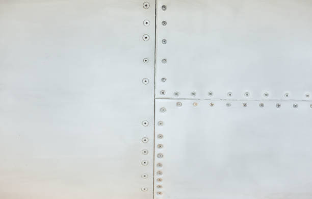 Silver metal surface of the aircraft fuselage with rivets. Fuselage detail view. Airplane metallic fuselage detail with rivets. Silver metal surface of the aircraft fuselage with rivets. Fuselage detail view. Airplane metallic fuselage detail with rivets. fuselage stock pictures, royalty-free photos & images