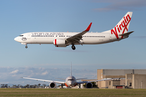 Melbourne, Australia - June 23, 2015: Virgin Australia Airlines Boeing 737-800 airliner about to land at Melbourne Airport while a Jetstar Airways Boeing 787 waits to depart.