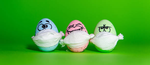 istock Funny three eggs in a mask for Easter isolated on a green background 1217721414