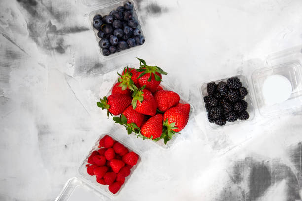 istock strawberries, blueberries, raspberries and blackberries, lie in plastic containers on a white background 1217724366