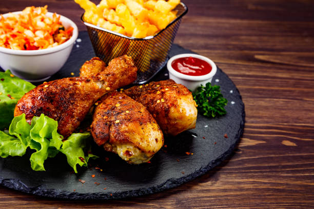 istock Roast chicken drumsticks and vegetables served on cutting board 1217724417