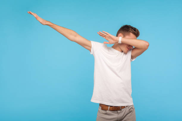 porträt von aufgeregt enhappy mann in weißen t-shirt zeigt dab tanz, beliebte internet-meme-pose - dab tanz stock-fotos und bilder