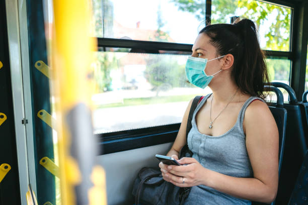 istock Woman in bus wearing face mask 1217725704