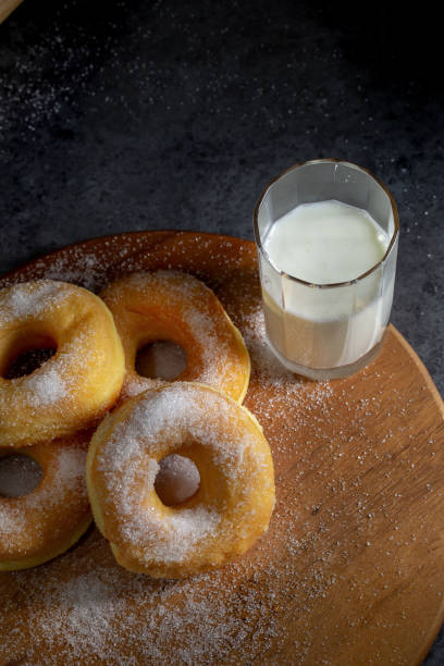 istock Donuts with sugar on a wooden plate over a dark table background. 1217727620
