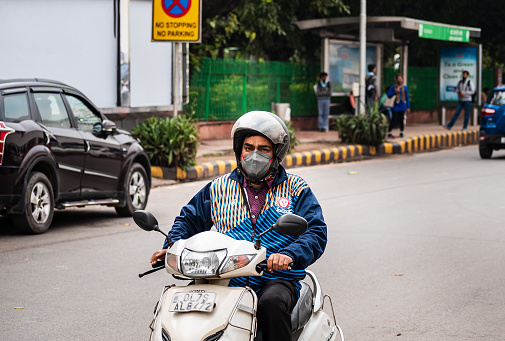 New Delhi, Delhi, India - 03/07/2019: Indian people riding motorcycle amidst Covid 19 outbreak and lockdown curfew.