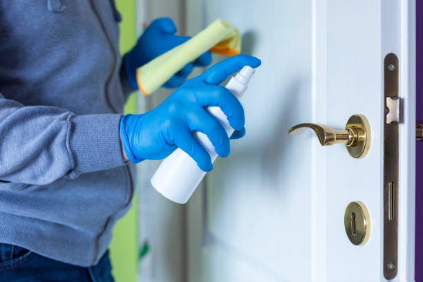 istock Spraying door knob with spray disinfectant 1217728126