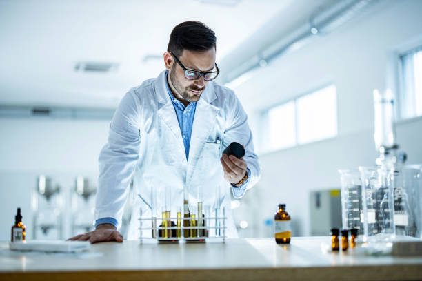 Young medical expert working on a virus medicine in laboratory. Young male scientist examining his medical research while working in laboratory. medical cannabis stock pictures, royalty-free photos & images