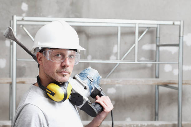 portrait of man construction worker with jackhammer with safety hard hat, hearing protection headphones and protective glasses. look at the camera isolated on interior building site background - home improvement work tool hammer portrait imagens e fotografias de stock
