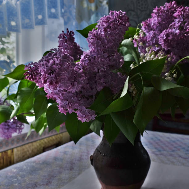 istock Lilac bouquet in a ceramic vase on the table. 1217731167