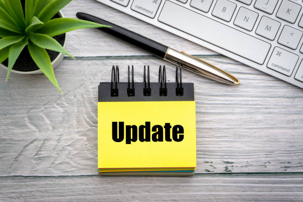 istock UPDATE text with decorative flower, fountain pen, keyboard and notepad on wooden background 1217732484