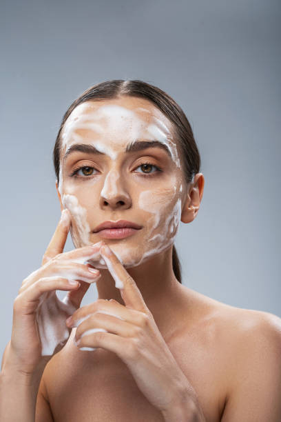 istock Serene woman cleaning her face with foam 1217732913