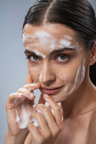 istock Cheerful young woman using foam for facial 1217732927