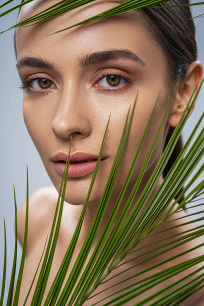 istock Pretty young lady with green palm leaf 1217732982