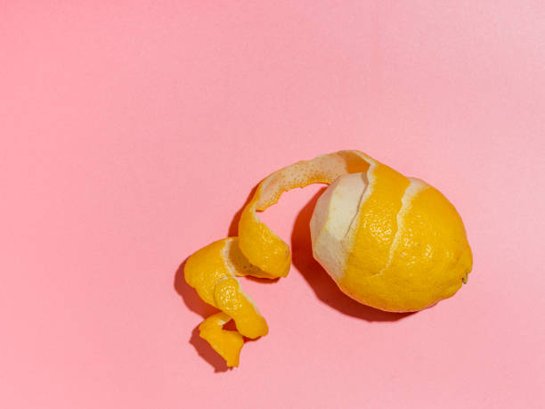 istock Lemon and spiral peel on pink background hard light 1217734762