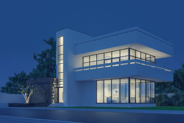 istock Modern house with white plaster with a balcony and a high staircase, in cold night light with warm light from the Windows against the background of trees and a white fence 3D stock illustration. 1217738396