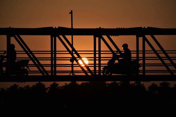 istock Silhoutte of bikes on a bridge during sunset 1217738412