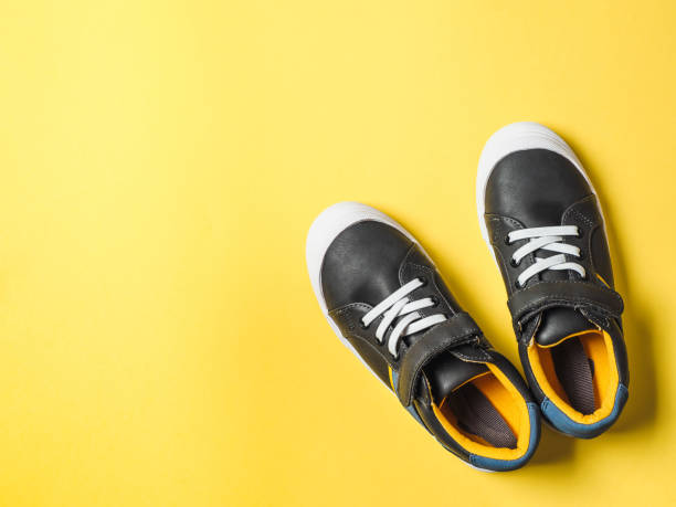 istock Gray and yellow sneakers on yellow background 1217738603