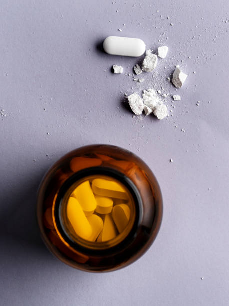 коричневая транспарен стеклянная бутылка с таблетками, рецептурные лекарства, таблетки и таблетки в темной стеклянной бутылке, - store herbal medicine drug abuse capsule стоковые фото и изображения