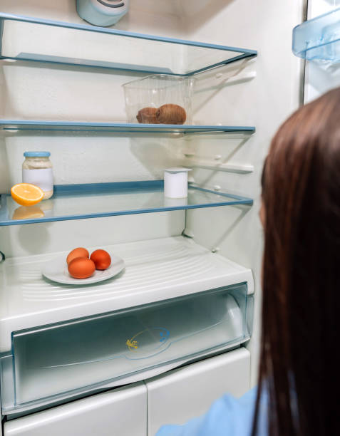 istock Girl looking at empty fridge due to a crisis 1217740399