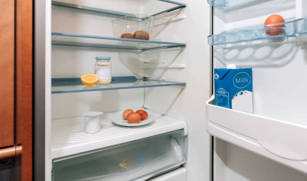 réfrigérateur presque vide en raison d’une crise - frigo ouvert photos et images de collection