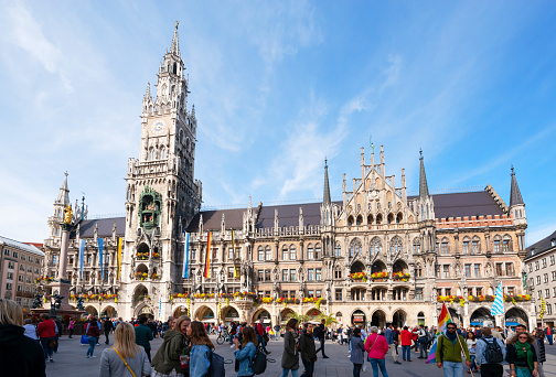 Munich, Germany - September 20, 2020: Very busy Marienplatz, in the city center of Munich with many shops. Historical city hall with the world famous carillon clock tower in middle.