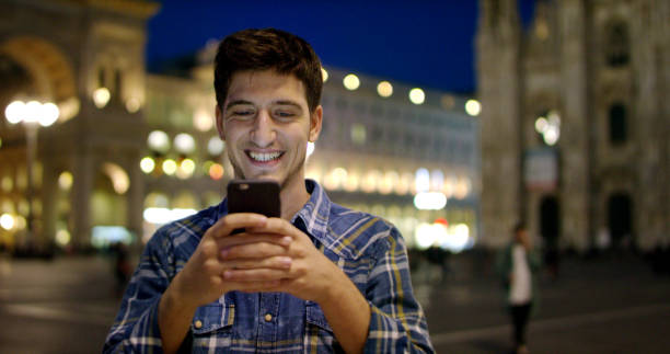 istock Smart phone man texting on mobile phone at night in city. 1217745780