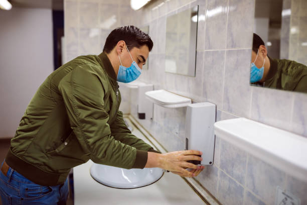istock Man washing his hands to avoid diseases like coronavirus Man with a face mask washes his hands in a public bathroom 1217746853
