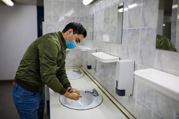 istock Man washing his hands to avoid diseases like coronavirus Man with a face mask washes his hands in a public bathroom 1217747121