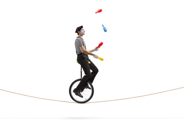 ロープの上でモノサイクルに乗ってジャグリングするマイム - unicycle unicycling cycling wheel ストックフォトと画像