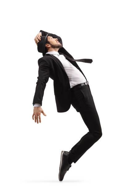 istock Man in a black suit dancing and holding his hat 1217751365