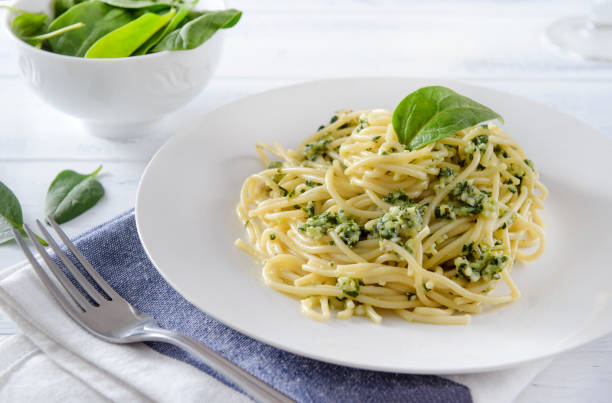 istock spaghetti with spinach, fork on a white background close-up, 1 plate of pasta, 1217751380