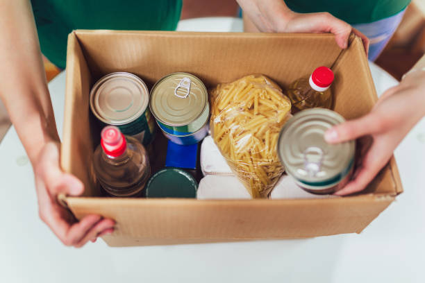 Volunteer with box of food for poor. Donation concept. Volunteer with box of food for poor. Donation concept. homelessness photos stock pictures, royalty-free photos & images