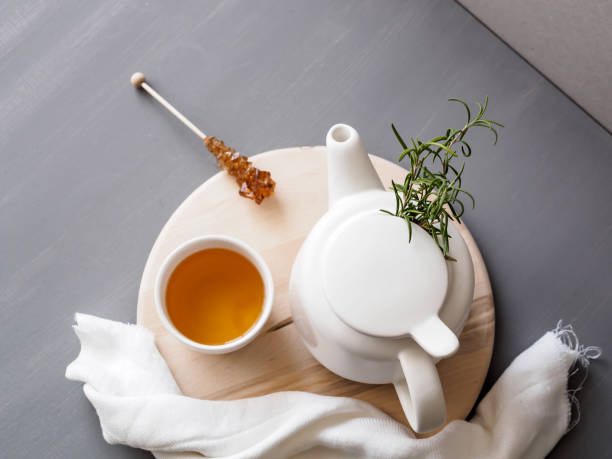 istock A cup of herbal tea and a white teapot on a serving tray on a gray kitchen table, top view 1217755394