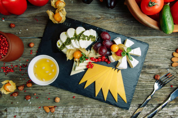 istock Slicing cheeses on a stone Board. Set of cheese with honey and nuts. 1217756847
