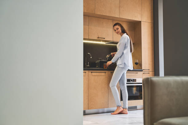 istock Lovely barefoot girl standing in the kitchen 1217759305