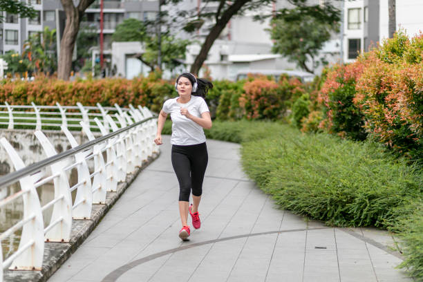istock a young woman running and doing exercise at public park 1217759399