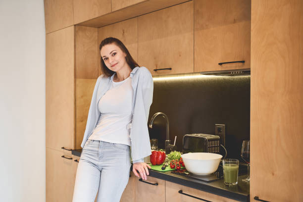 istock Beautiful woman leaning against a kitchen counter 1217759482