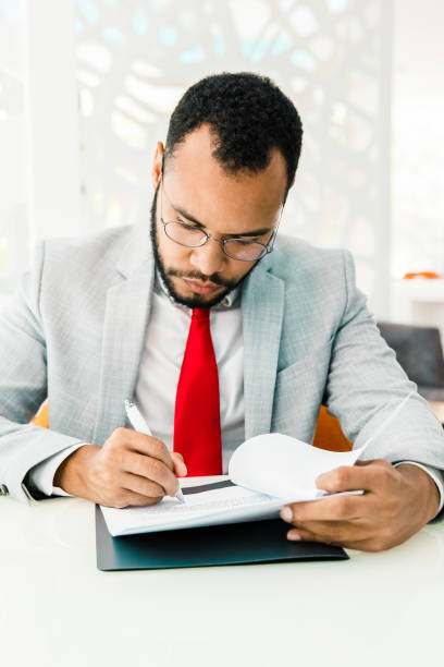 istock Serious businessman writing on papers 1217760198