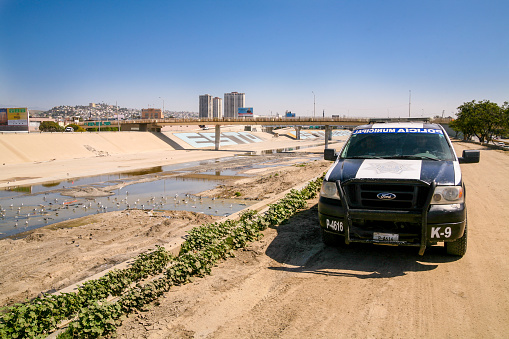 Tijuana, Mexico, March 09 -- A police patrol checks the dirty water canal that runs alongside the Mexican-US border in Tijuana, on the Pacific coast, near the San Ysidro international border station.