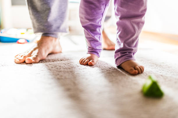 istock First steps of baby with the help of dad 1217761941