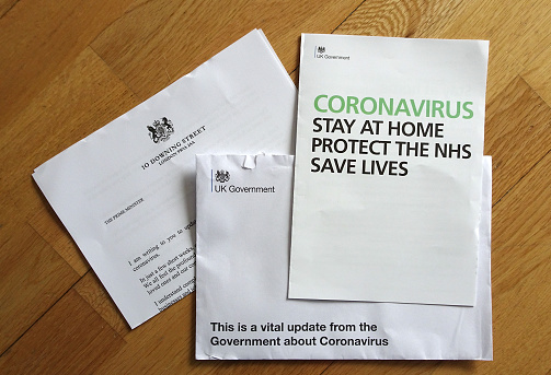 London, United Kingdom - April 08, 2020: Wooden table and letter from prime minister with information & advisory about coronavirus covid-19 outbreak that all people in UK received by mail