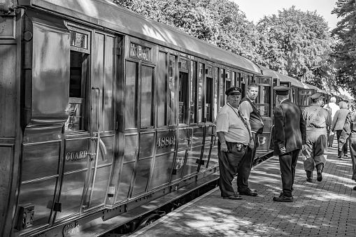 Black and white photo of train conductors next to a traditional wooden train carriage on Holt station on the Norfolk Poppy Line.

This photo was captured at the 2019 1940’s weekend held in Sheringham and Holt. This vintage event is a free to enter and open to all, with no restrictions. The general public have access to all areas and the two towns actively promote the event and invite visitors from all over the UK, and beyond, to get dressed up in vintage attire and turn up to enjoy what the towns have to offer.