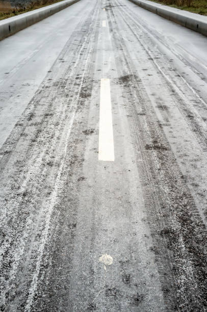 istock Frozen asphalt road with markings, curbs and sidewalks, in fog, on a cold winter day. 1217763515