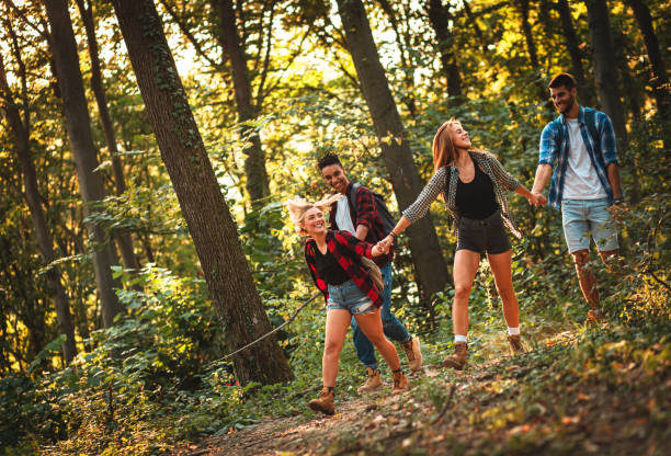 istock Group of four friends having fun hiking through forest together. 1217765680