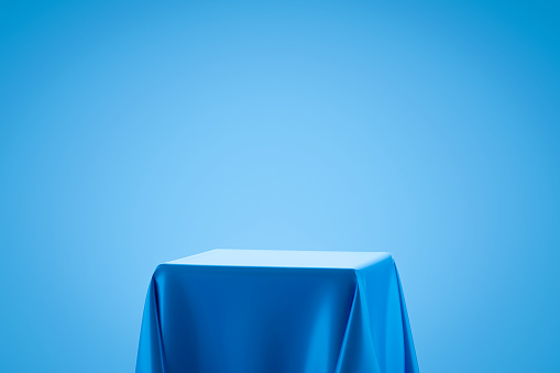 Blue fabric on podium shelf or empty studio display on light blue gradient background with art style. Blank stand for showing product. 3D rendering.