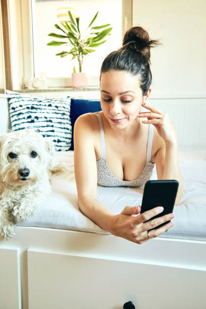 istock Cute girl relaxing after gym with dog while using cellphone. 1217767311