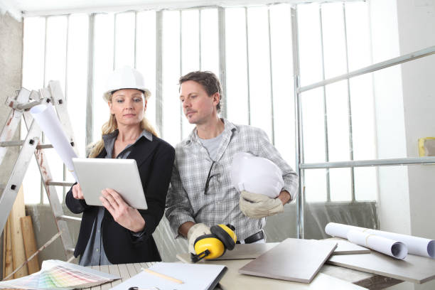 istock man and woman architect interior designer and foreman worker together with computer and decorative materials discussing the project for interior decoration in the inside the construction building site 1217768682